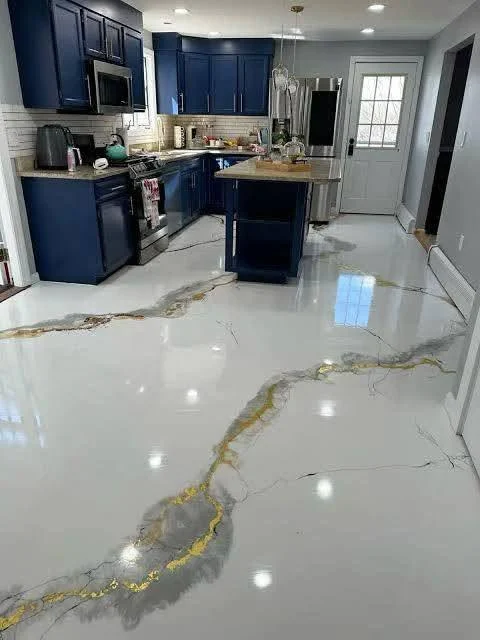 Lacivert dolaplı mutfakta altın ve gri desenli parlak zemin
