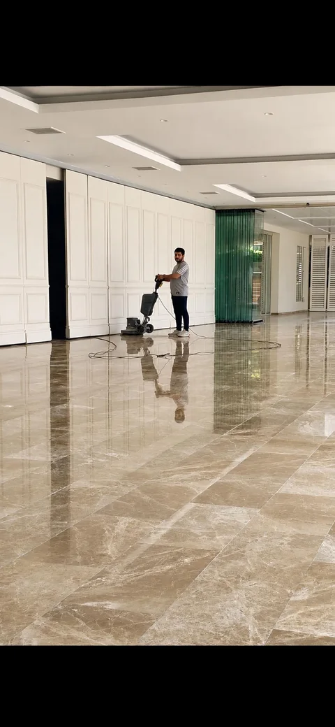 Geniş mermer zeminde silim makinesiyle çalışan uygulamacı